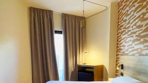 A hotel room with a bed, a desk, a lamp, and a patterned wall. - Hotel Playa Mallorca (Palma de Mallorca)