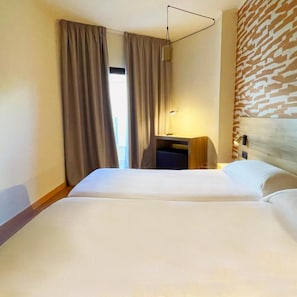 A hotel room with a bed, a desk, a lamp, and a patterned wall. - Hotel Playa Mallorca (Palma de Mallorca)