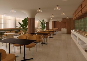 Un espace repas moderne, doté de tables et de chaises, d’un comptoir de buffet et de grandes fenêtres.