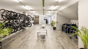 A modern indoor space with bicycles, seating, and luggage racks. - Hotel Playa Mallorca (Palma de Mallorca)