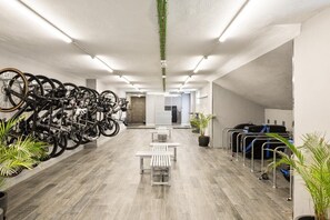A modern indoor space with bicycles, seating, and luggage racks. - Hotel Playa Mallorca (Palma de Mallorca)