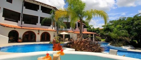 A pool area with a clear view of a building with multiple windows and a tiled roof.