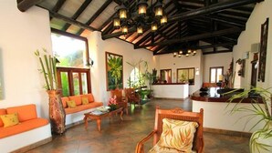 A spacious lobby with a reception desk, seating area, and large windows. - Sugar Cane Club Hotel & Spa (Speightstown)