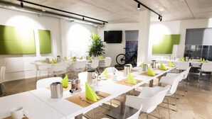 A modern conference room with white tables, chairs, and green accents. - The Bricks Hotel Marktredwitz (Marktredwitz)