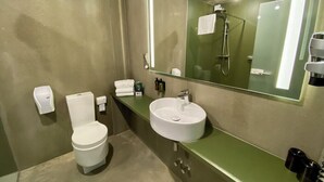 A bathroom with a toilet, sink, and mirror. - The Bricks Hotel Marktredwitz (Marktredwitz)
