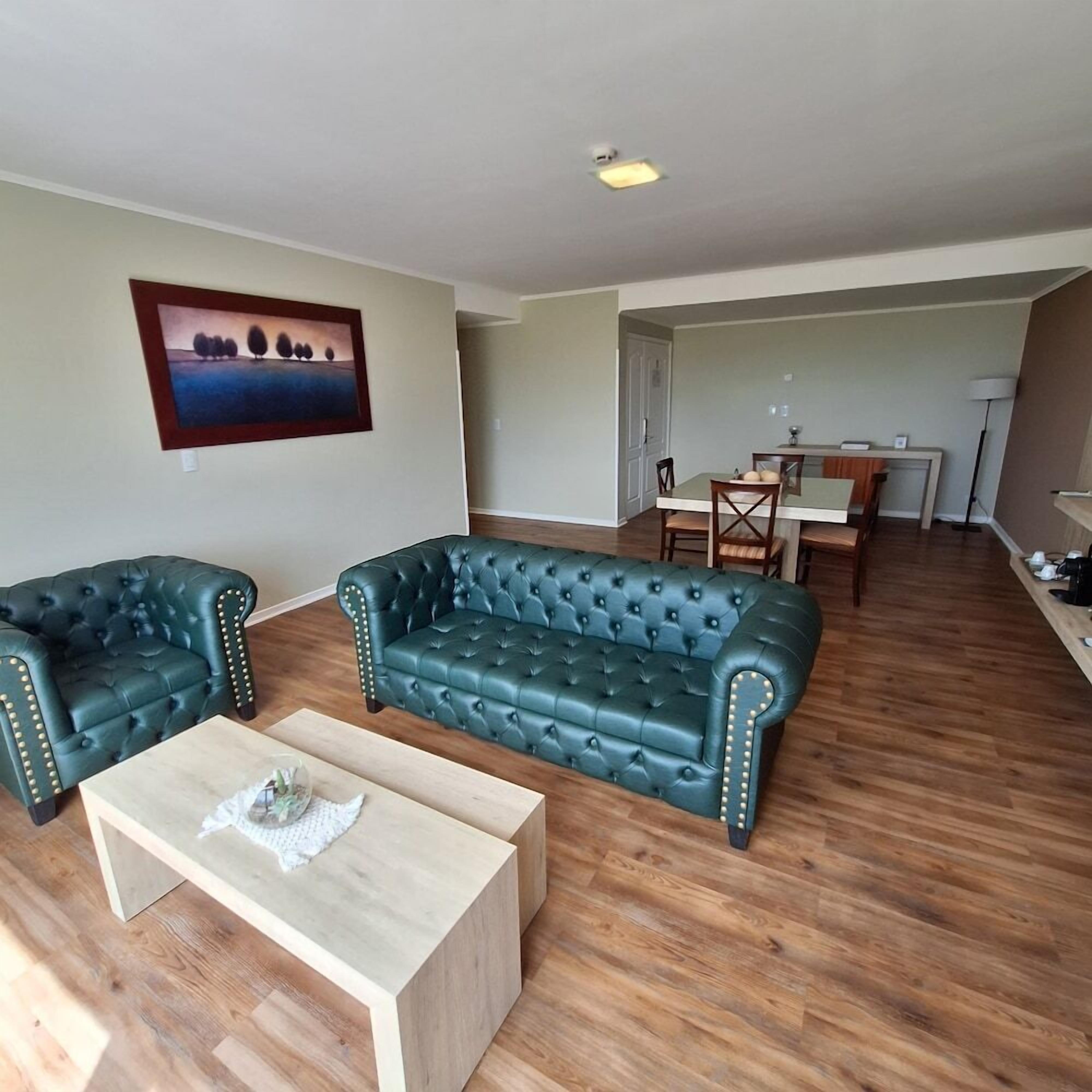 Un salon comprenant un ensemble de canapés, une table basse et un coin repas avec une table et des chaises.