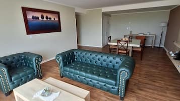 Un salon comprenant un ensemble de canapés, une table basse et un coin repas avec une table et des chaises.
