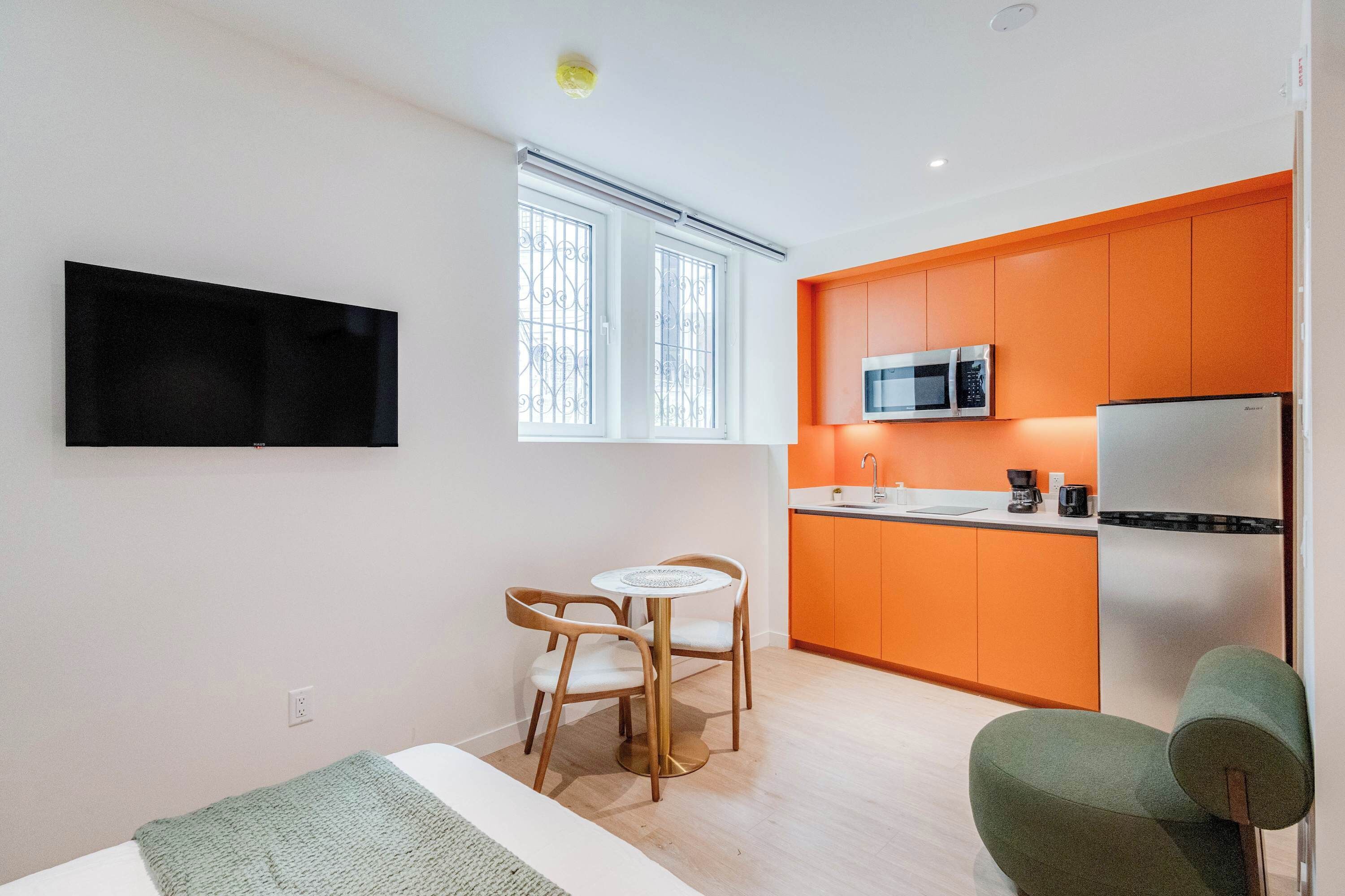 A compact living space with a kitchenette, a dining area, and a seating area.