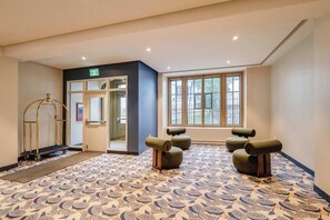 A hotel lobby with a patterned floor, a reception desk, and a large window with a view. - 001 Cook - Loft in the Heart of Old Quebec (Québec)