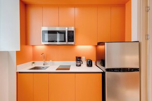A compact kitchen with a microwave, refrigerator, sink, and coffee maker. - 001 Cook - Loft in the Heart of Old Quebec (Québec)