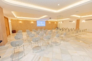 A conference room with a large screen displaying 'BAHIA PRINCIPE HOTEL & RESORTS' at the front. - Bahia Principe Explore Esmeralda (Punta Cana)
