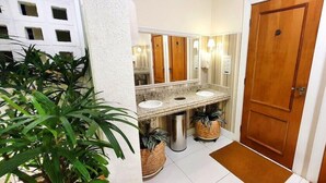 Casa de banho com duas pias, um espelho e uma porta de madeira.