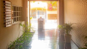 A corridor with a wooden ceiling, potted plants, and a view of an outdoor area. - The Palm at Playa (Playa del Carmen)