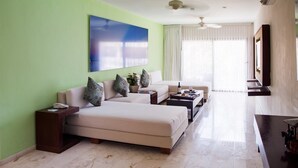 A hotel room with a large bed, a sofa, a coffee table, and a TV. - The Palm at Playa (Playa del Carmen)