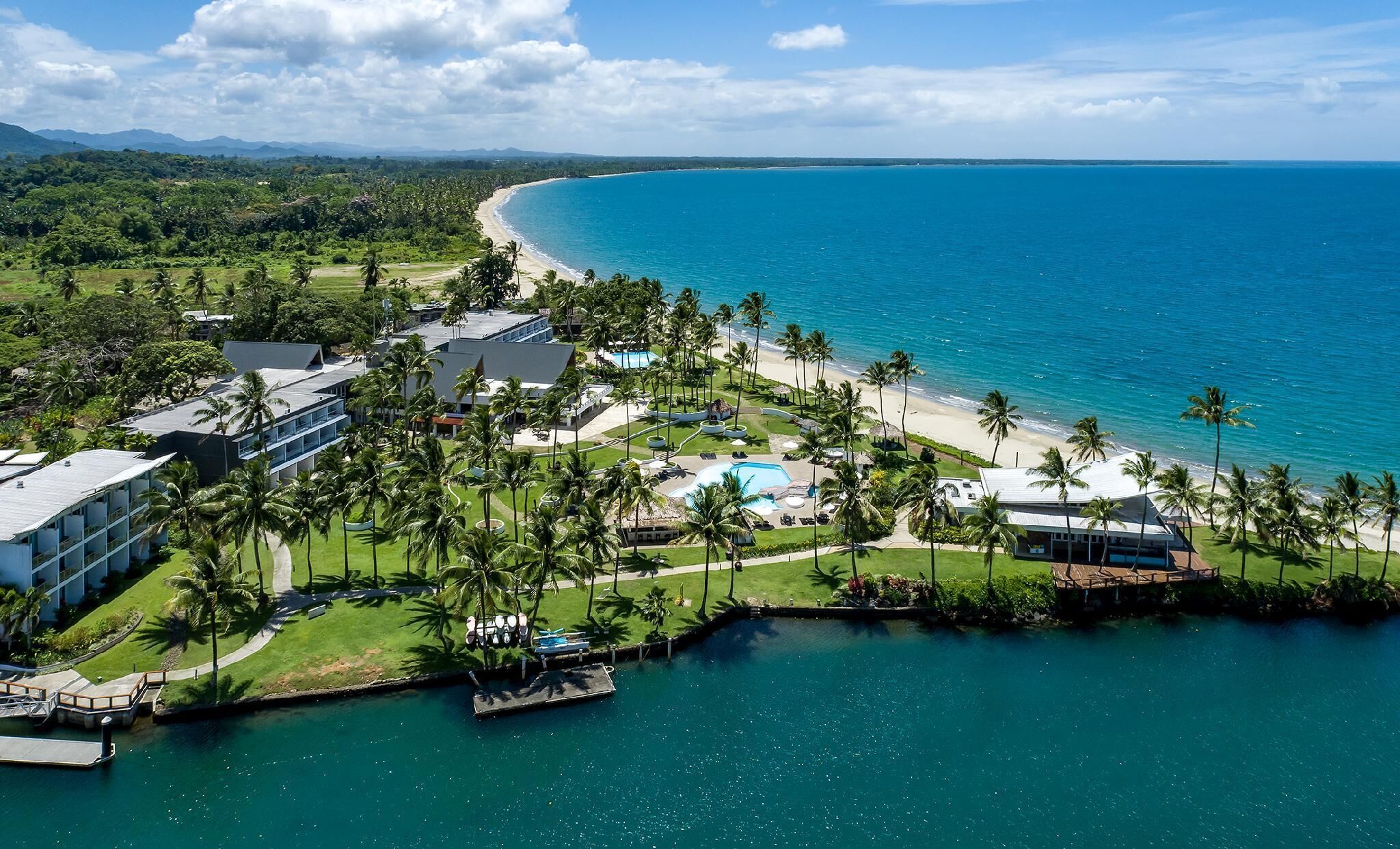 Un resort con piscina, playa y vista al océano.