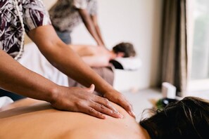 Sessão de massagem em andamento, com destaque para as mãos do terapeuta.