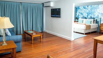 Una sala de estar moderna con un sofá, una mesa de centro y un televisor montado en la pared.