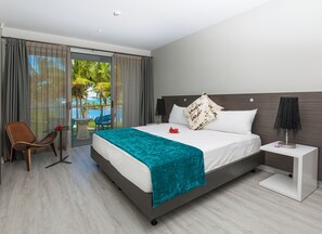 A hotel room with a bed, a chair, a table, a nightstand, and a view of the outdoors. - The Pearl Resort Spa & Golf Course (Pacific Harbour)