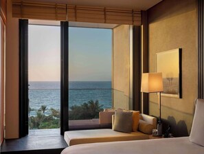 A hotel room with a large window, a bed, a sofa, and a lamp. - Banyan Tree Dubai (Dubai)