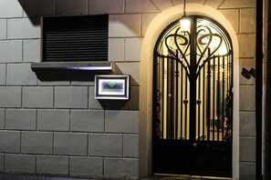 Un ingresso recintato con un cancello in ferro battuto decorativo, una piccola finestra con bocchetta di ventilazione e un cartello per Wyndham Residences.
