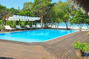 A swimming pool with lounge chairs and a wooden deck.