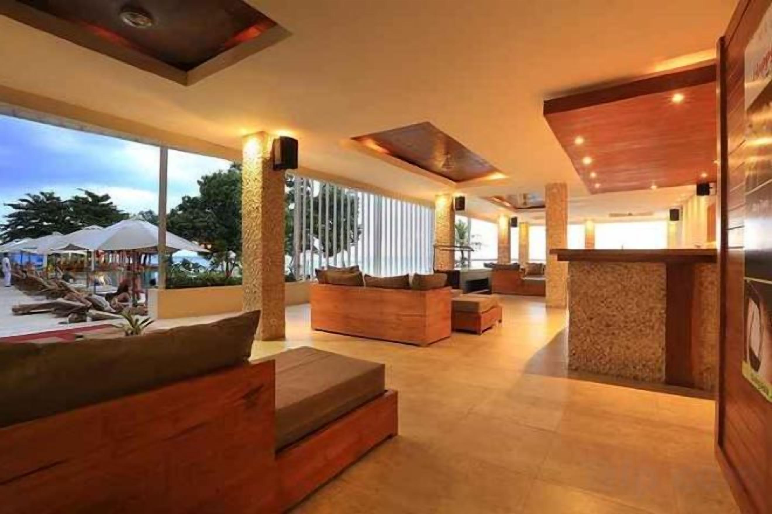 A spacious lobby with a reception desk, seating area, and large windows.