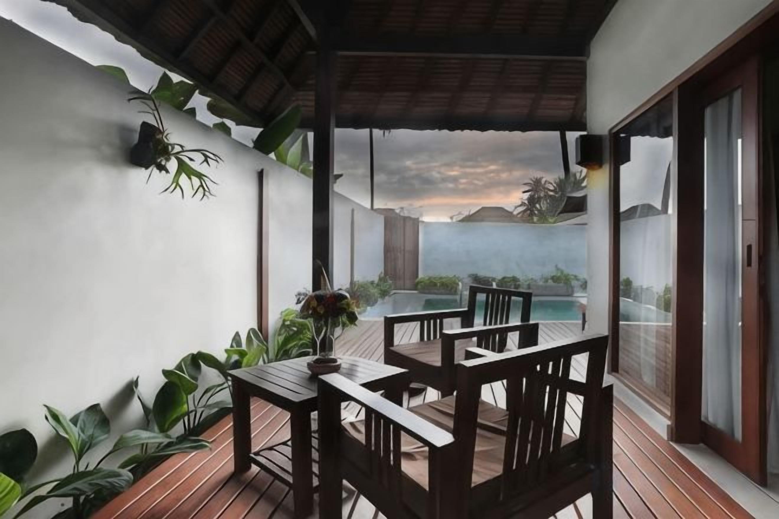 A covered outdoor seating area with a table and chairs, overlooking a pool and a mountainous landscape.