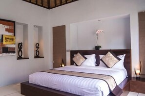 Una habitación de hotel con una cama grande, un cabecero de madera y una mesita de noche con una lámpara.