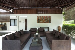 A modern living area with a sofa set, a coffee table, and a painting on the wall. - Living Asia Resort and Spa (Malaka)