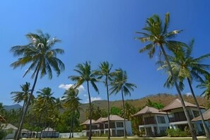 A resort with multiple buildings, palm trees, and a clear sky. - Living Asia Resort and Spa (Malaka)