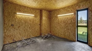 A room with wooden walls, a concrete floor, and a large window.