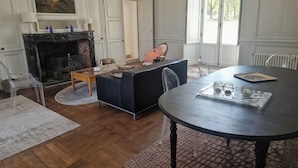 A room with a fireplace, a dining table, and a large window. - A wing of a charming 18th-century château, fully renovated and set in a magnificent park (Saint-Étienne-de-Montluc)