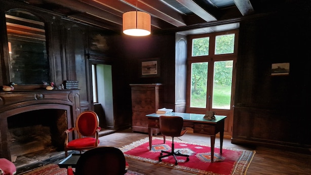 A room with a fireplace, two chairs, a desk, and a large window. - A wing of a charming 18th-century château, fully renovated and set in a magnificent park (Saint-Étienne-de-Montluc)