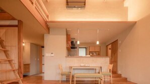Un intérieur moderne comprenant un coin repas, une cuisine et un escalier.