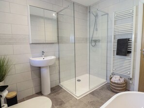 A modern bathroom with a glass-enclosed shower, a pedestal sink, and a white bathtub. - Tyn Y Weirglodd (Caernarfon)