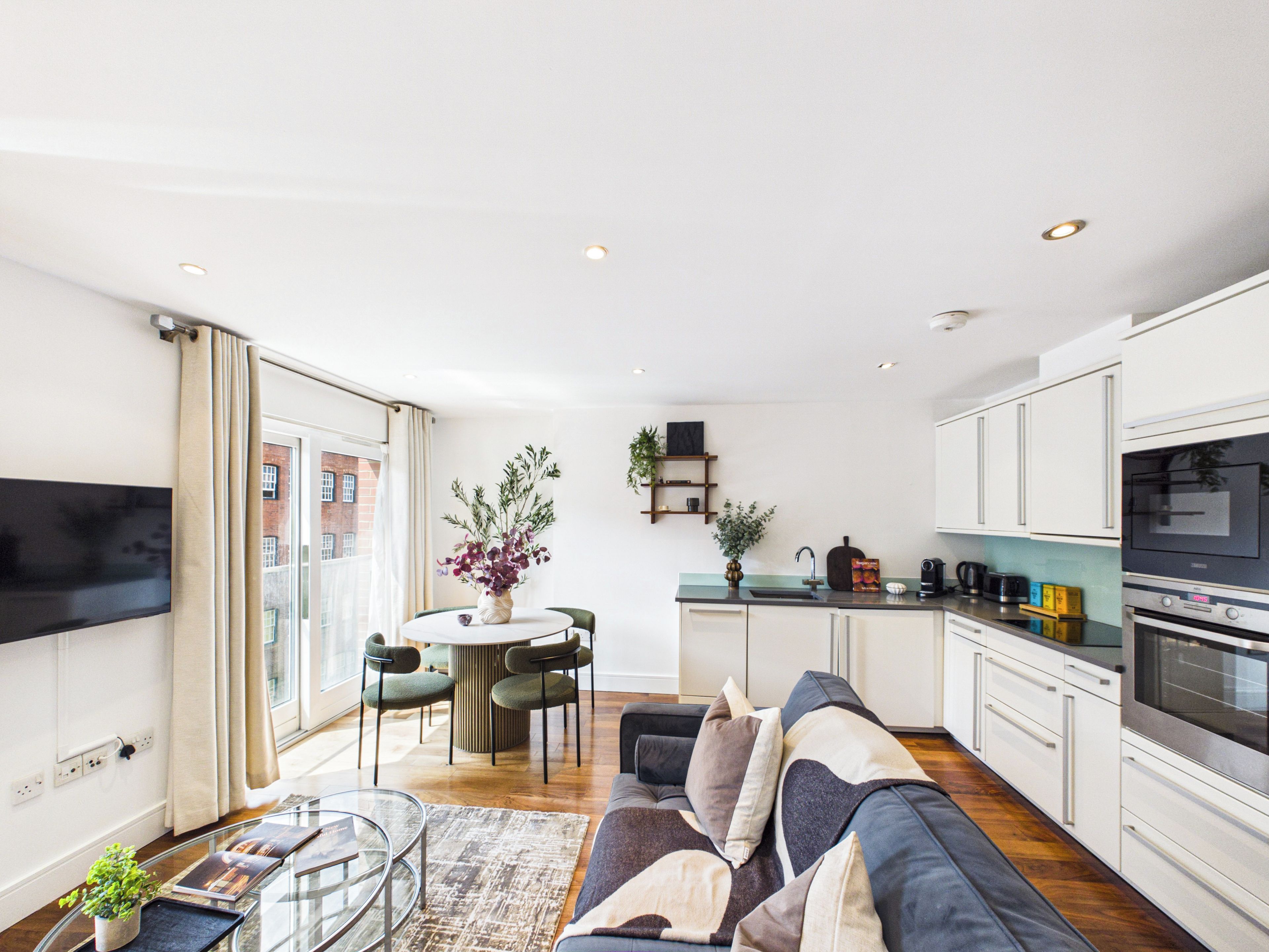 A modern living space with a dining area, kitchen, and seating area.