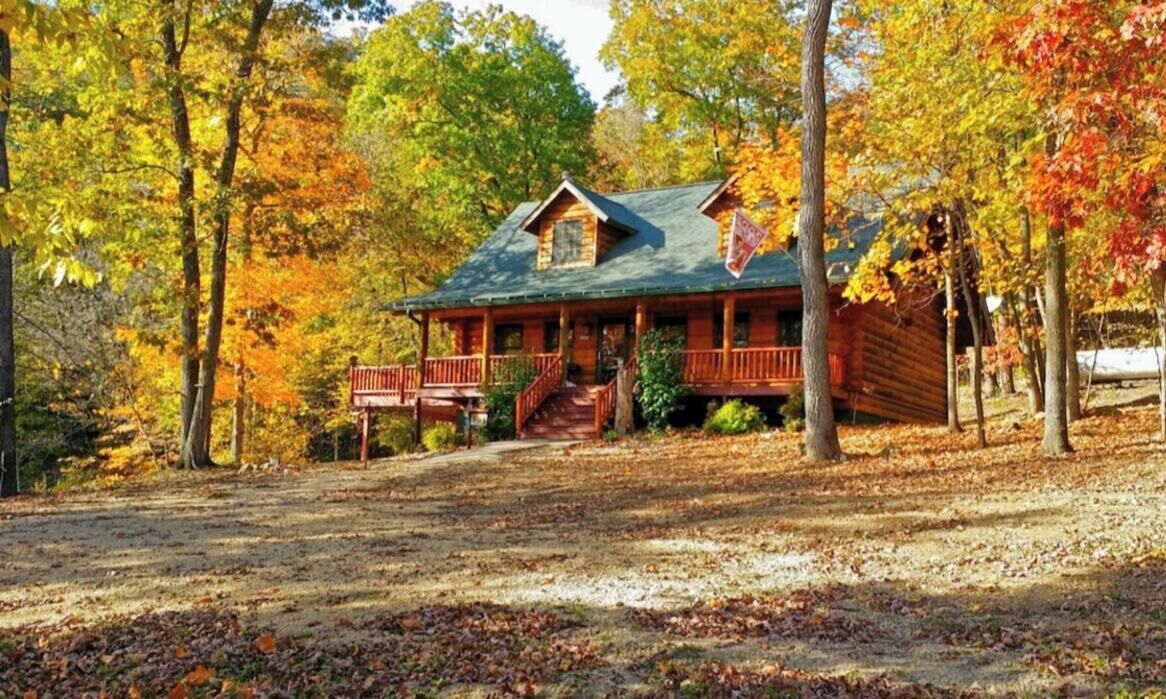 A log cabin with a porch and a staircase leading to the entrance.