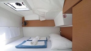 A small, compact room with a bed, a ceiling fan, and a window. - Excess 11 - DIOSCURI (Pula)