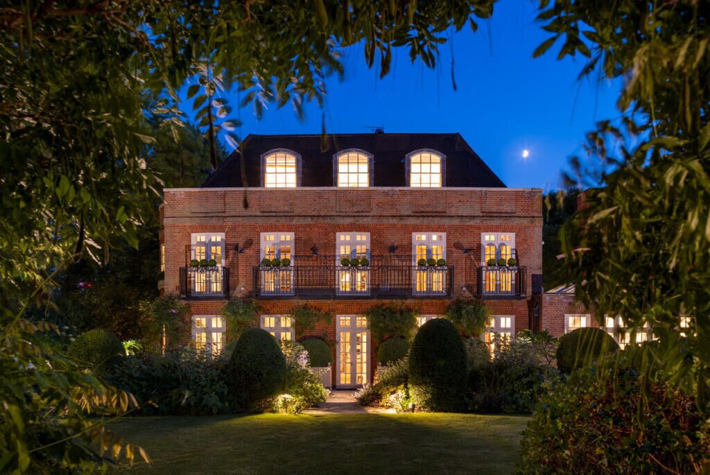 A two-story brick building with a symmetrical facade, multiple windows, and a central entrance.