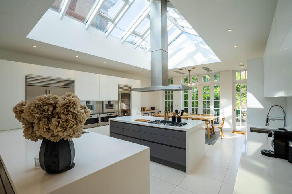 A modern kitchen with a central island, built-in appliances, and a skylight.