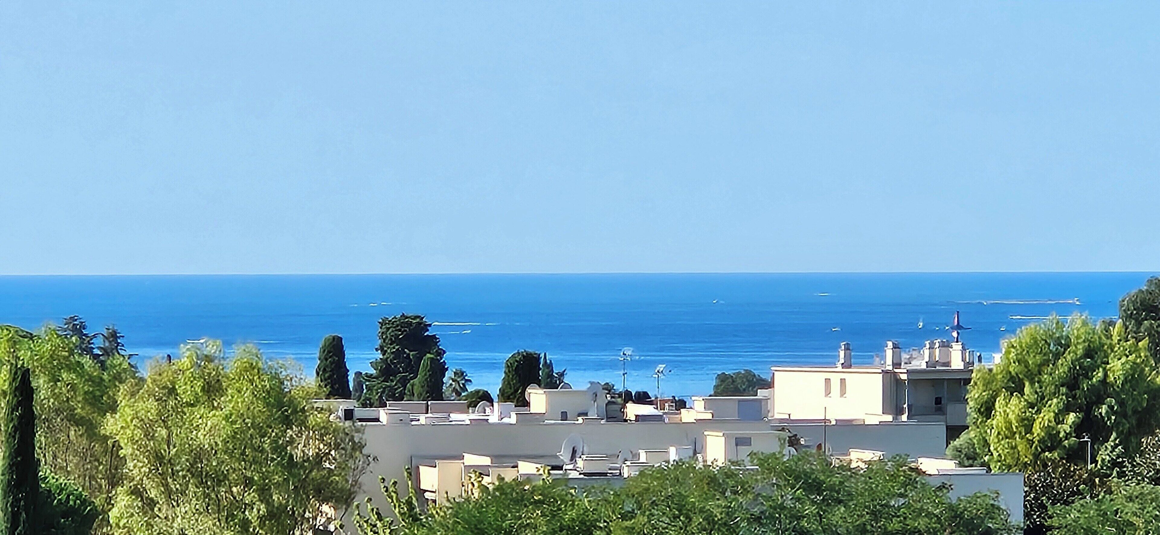 Paesaggio costiero urbano con edifici e una vista limpida del mare.