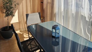 A glass table with a chair, a potted plant, and a lantern on a balcony with a view. - Charming 2-room apartment - Ocean view - Pool - Parking - Antibes (Antibes)