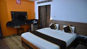 Una habitación de hotel con cama, televisión, escritorio y baño.