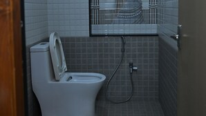 Un baño pequeño con inodoro, ducha y lavamanos.