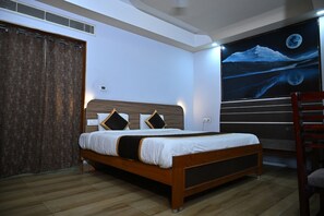 A bedroom with a bed, a wall-mounted TV, and a wooden floor. - Smart Inn The Luxurious Stay (Visakhapatnam)