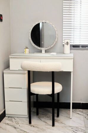 A bathroom vanity with a round mirror, a white sink, and a white toilet. - S&J Home of Comfort (Accra)