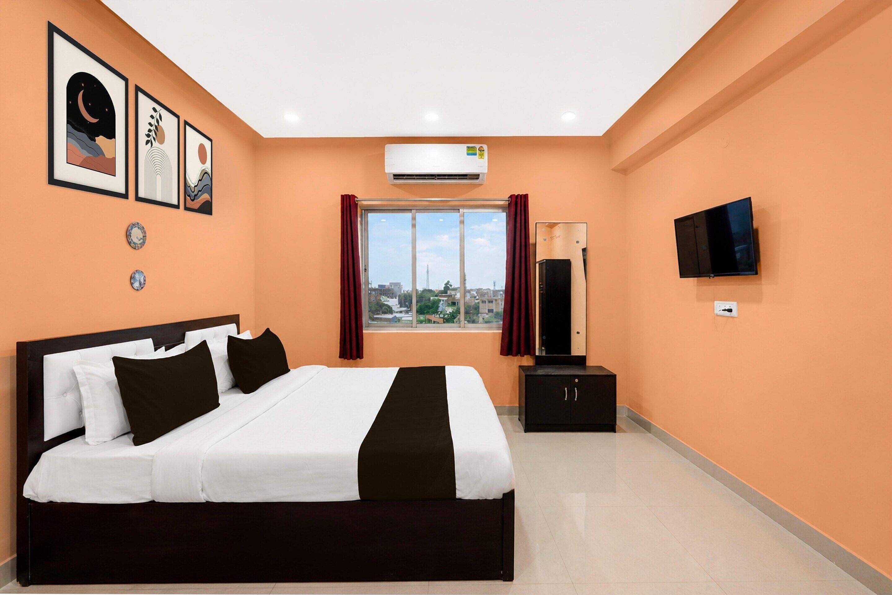 Ein Hotelzimmer mit einem Bett, einem Fernseher, einer Klimaanlage und einem fenster mit Vorhängen.