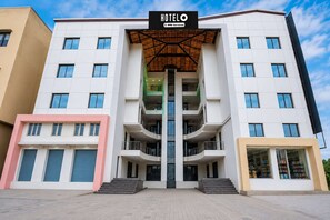 Un hotel con un atrio central, varios pisos y un letrero que indica que cuenta con los servicios de OYO.