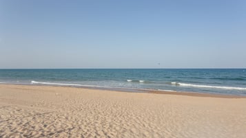 Uma praia com areia e ondas.