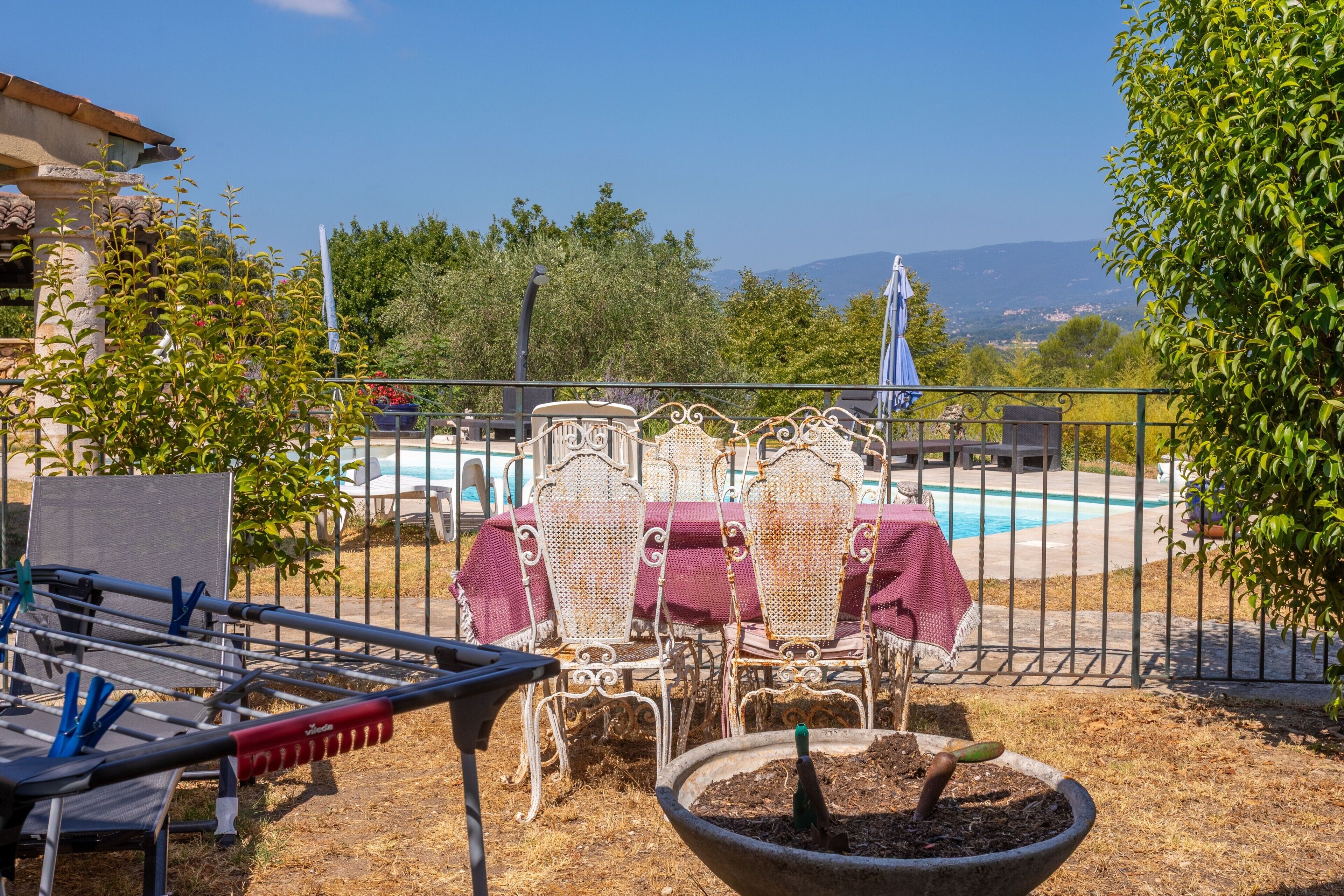 A patio with outdoor furniture, a pool, and a view of the mountains.